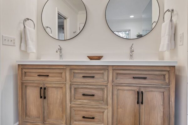 Round, metal framed vanity mirrors complement this master bath.