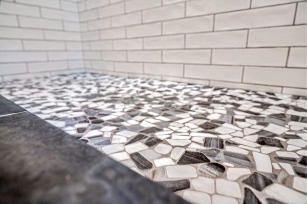 Peeble mosaic tile contrasts the subway tile in this remodeled shower.