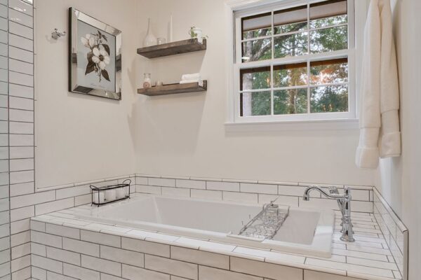 Tile surround, and backsplash provide attractive protection from splashing water in this drop in soaking tub.