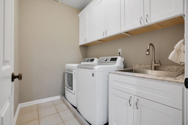 Newly remodeled laundry space with new white shaker cabinets.